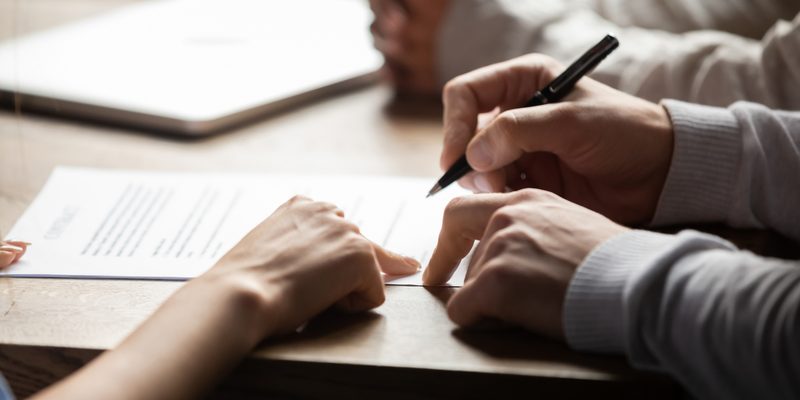 Solicitor pointing at contract showing client where to write signature